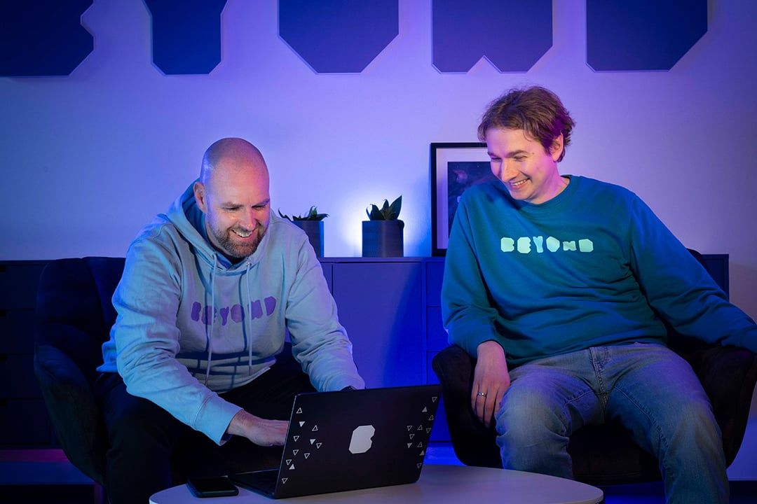 Two people from the BEYONDIT team working together on a Business Central solution at a laptop